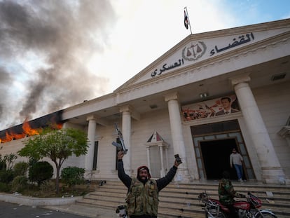 Combatentes da oposição comemoram ao incendiar um tribunal militar em Damasco, Síria, domingo, 8 de dezembro de 2024. (AP Photo/Hussein Malla)