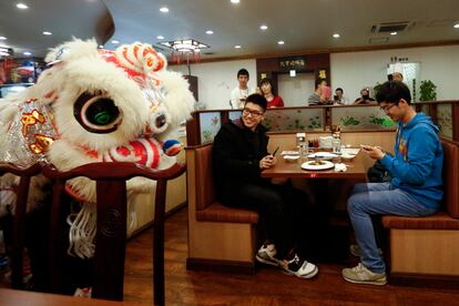 Clientes de un restaurante se divierten con la actuación de unos bailarines durante la celebración del Año Nuevo Chino en Yokohama (Japón).