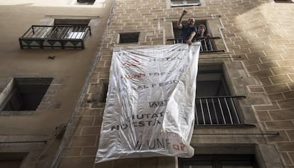 Unos vecinos desplegando una pancarta contra los pisos tur&iacute;sticos.