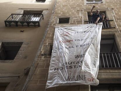 Unos vecinos desplegando una pancarta contra los pisos tur&iacute;sticos.