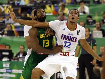 Rudy Gobert, con camiseta con mangas, siendo interceptado por Nene Hilario, de Brasil, en el partido del sábado 30 de agosto de 2014.