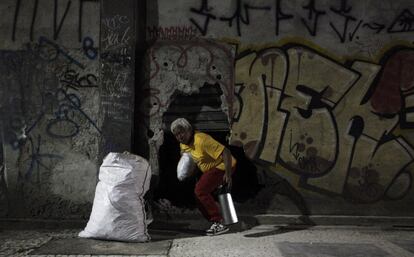 Um membro do Movimento dos Sem-Teto (Movimento Sem Teto) do Brasil sai para o trabalho através de um buraco feito com uma marreta em um dos 11 edifícios vazios que o movimento tomou em uma noite, no centro de São Paulo, em foto tirada no dia 29 de outubro de 2012.