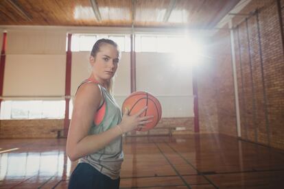 high-school-girl-standing-with-basketball-in-the-c-7AU2BMD copia
