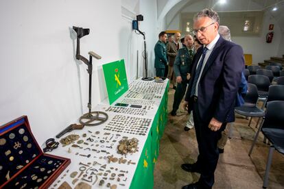 El delegado del Gobierno de Extremadura, José L. Quintana observa las monedas incautadas en la denominada 'Operación Tamussia', este martes en el Museo de Cáceres.