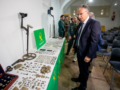 El delegado del Gobierno de Extremadura, José L. Quintana observa las monedas incautadas en la denominada 'Operación Tamussia', este martes en el Museo de Cáceres.