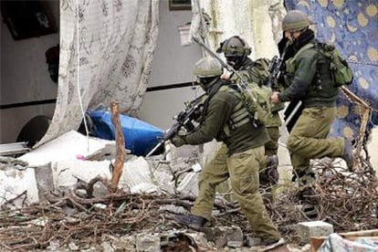 Soldados israelíes entran en una casa palestina después de destruirla ayer en Balata, cerca de Nablus.