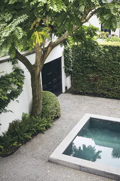 El árbol del jardín de la casa ya estaba allí cuando el diseñador llegó. El portón, al igual que la puerta principal, está lacado en negro.