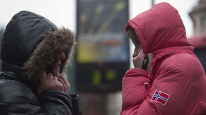 Dos mujeres se protegen del frío en Bilbao.