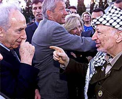 Yasir Arafat (derecha) conversa con el ministro de Exteriores israelí, Simón Peres, ayer en Lisboa.