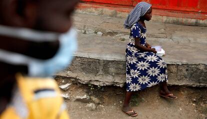 Una niña se dispone a comer en una acera después de haber recibido una ración de alimento de un grupo de voluntarios que distribuye comida a personas sin hogar en Accra, Ghana, el 4 de abril de 2020.  