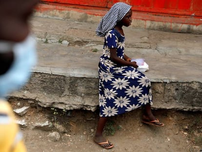 Una niña se dispone a comer en una acera después de haber recibido una ración de alimento de un grupo de voluntarios que distribuye comida a personas sin hogar en Accra, Ghana, el 4 de abril de 2020.  