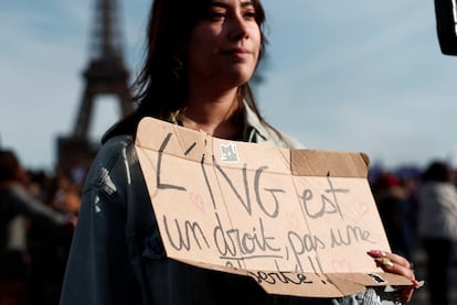 Una mujer sostiene un cartel que dice "el aborto es un derecho, no una libertad", mientras sigue la sesión parlamentaria desde la plaza de Trocadero, en París, este lunes.