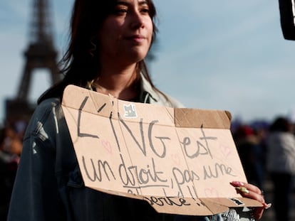 Una mujer sostiene un cartel que dice "el aborto es un derecho, no una libertad", mientras sigue la sesión parlamentaria desde la plaza de Trocadero, en París, este lunes.