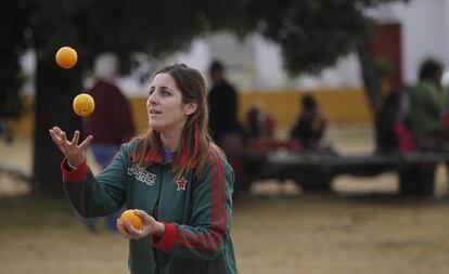 Una jornalera se entretiene durante la ocupación con unas naranjas.