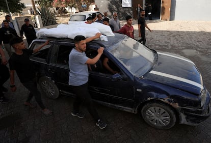 Varias personas trasladan el cadáver de varios niños muertos tras una bombardeo israelí sobre una escuela en Ciudad de Gaza, este lunes.  