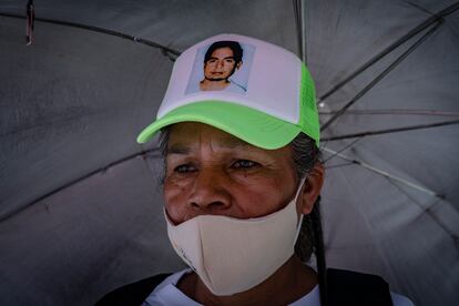 Una mujer con la fotografía de su hijo desaparecido en la gorra, durante la marcha de este martes.