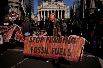 Un activista protesta frente al Banco de Inglaterra, en Londres, con una pancarta que pide el fin de la financiación para los combustibles fósiles.