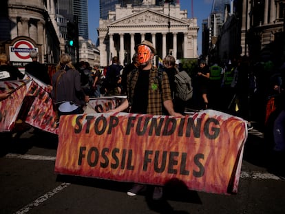 Un activista protesta frente al Banco de Inglaterra, en Londres, con una pancarta que pide el fin de la financiación para los combustibles fósiles.