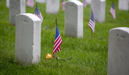 Una bandera estadounidense es vista sobre una lápida del Cementerio del Memorial en Arlington.  