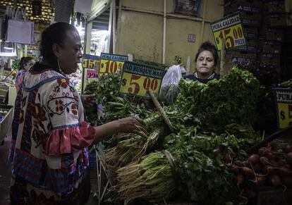 Una mujer compra verduras en un mercado de Ciudad de México.