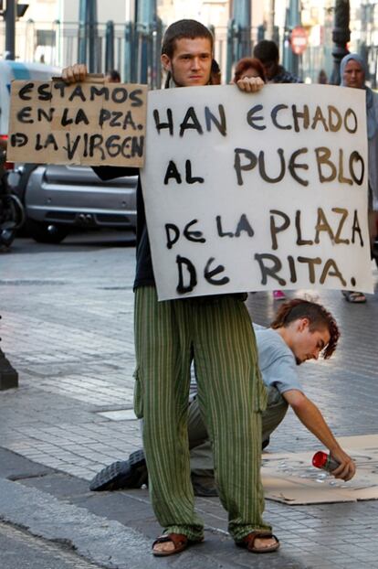 Un indignado porta una pancarta de protesta a escasos metros de la plaza del Ayuntamiento de Valencia.