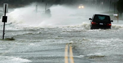 Un coche se impulsa a través del agua conducida en una carretera por huracán Sandy en Southampton, Nueva York, 29 de octubre de 2012