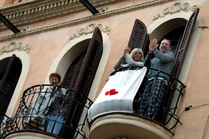 Vecinos de L'Hospitalet (Barcelona) aplauden en sus balcones este martes.