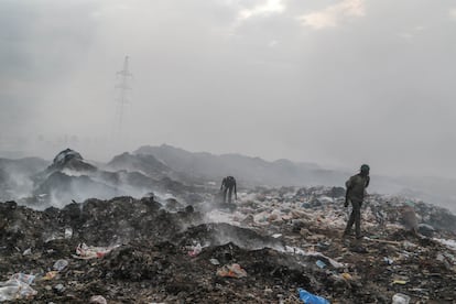 Varias personas hurgan entre residuos textiles y plásticos en un vertedero en Nakuru, en Kenia, en febrero de 2023.