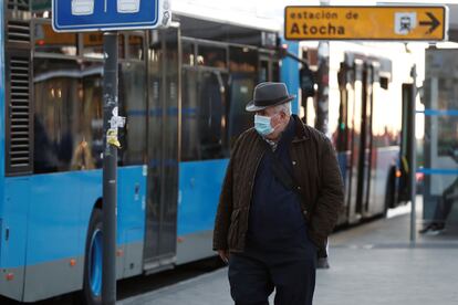 Un hombre protegido con una mascarilla transita las inmediaciones de la estación de Atocha (Madrid) este lunes.