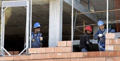 Tres alba&ntilde;iles trabajan en la construcci&oacute;n de una vivienda