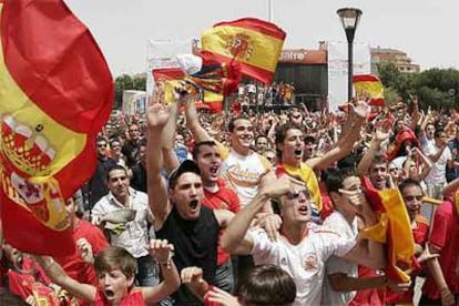 Miles de aficionados siguen la retransmisión de Cuatro en una pantalla gigante instalada en la plaza de Colón, en Madrid.