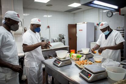  Moustapha Thiandoum, con mascarilla marrón, Abdoulaye Kande, con mascarilla azul y Mamadou Diouf (derecha), durante su curso de formación como pasteleros.  