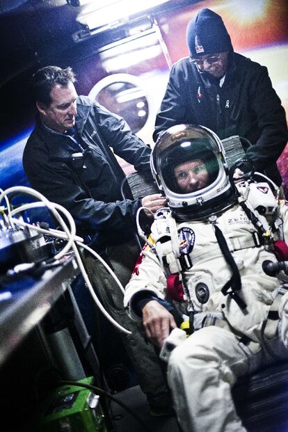 Miembros del equipo que ha preparado el reto parapetan a Baumgartner antes de iniciar la ascensión.