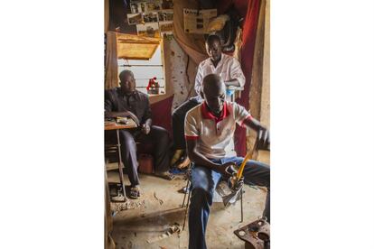 En la foto, Irou endulza el té a la manera africana. Los amigos de infancia se reúnen a diario en el taller de Aminu, en el barrio de Talladje, uno de los distritos de Niamey con mayor número de retornados. Allí pasan horas hablando, riendo, discutiendo, gritando y bebiendo té… Los retornados son conocidos como los “libios” y la mayor parte de los que frecuentan el local también residieron allí durante años.