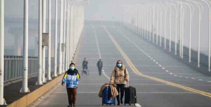 Una madre y su hijo llegan al punto fronterizo de la provincia de Hubei, en el puente Jiujiang, que cruza el río Yangtze. 