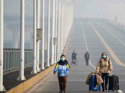 Una madre y su hijo llegan al punto fronterizo de la provincia de Hubei, en el puente Jiujiang, que cruza el río Yangtze. 