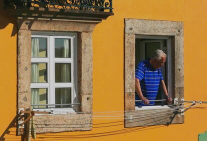 Un hombre mira por la ventana.