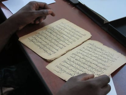 Gente leyendo algunos de los 377.000 manuscritos que se están restaurando y digitalizando, en Bamako (Malí).