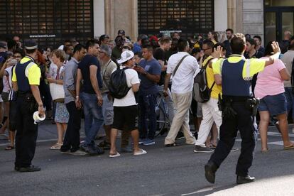 Efectivos de policía piden a la gente que se alejen de la zona del atentado ocurrido en Las Ramblas de Barcelona.