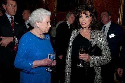 La reina Isabel II charla con la actriz Joan Collins en una recepción en el palacio de Buckingham, en Londres, en febrero de 2014.