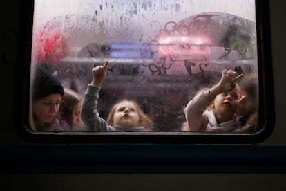 Dos niñas dibujan en el cristal de un vagón en la estación de tren de Lviv, cerca de la frontera de Ucrania con Polonia, el 2 de marzo.