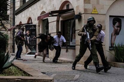 Soldados kenianos ayudan a escapar al personal del hotel donde se ha producido el ataque.