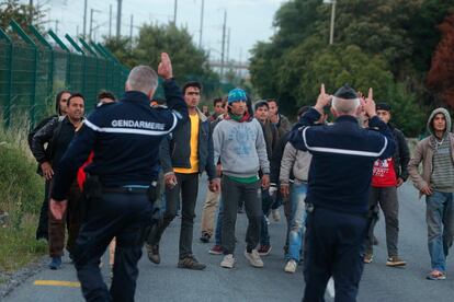 Agentes da polícia bloqueiam a passagem de migrantes para impedir o acesso aos trilhos que levam ao Túnel da Mancha, em Calais, norte da França.