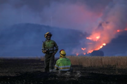 Momento de descanso de dos brigadistas en el incendio de Tábara. 