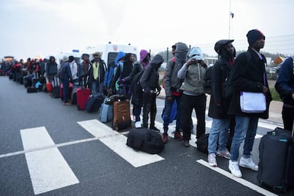 Fila de refugiados esperando ser evacuados del campamento de Calais, en octubre de 2016.