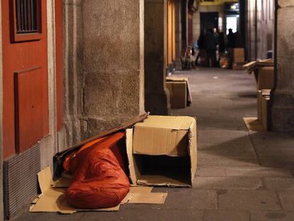 Una persona sin hogar durmiendo en los soportales de la plaza Mayor de Madrid.