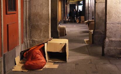 Una persona sin hogar durmiendo en los soportales de la plaza Mayor de Madrid.