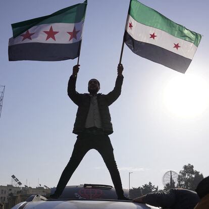 A man holds Syrian opposition flags as he celebrates after Syria's army command notified officers on Sunday that President Bashar al-Assad's 24-year authoritarian rule has ended, a Syrian officer who was informed of the move told Reuters, following a rapid rebel offensive that took the world by surprise, in Aleppo, Syria December 8, 2024. REUTERS/Karam al-Masri