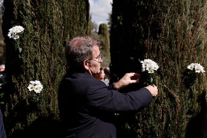 El presidente del PP, Alberto Núñez Feijóo, coloca flores blancas durante el acto en conmemoración de los atentados del 11-M celebrado en el Bosque del Recuerdo del parque de El Retiro, este lunes. 
