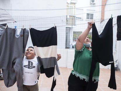 Andrei y Karen tendiendo la ropa en el patio interior de su casa.